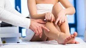 El médico examina la pierna del paciente